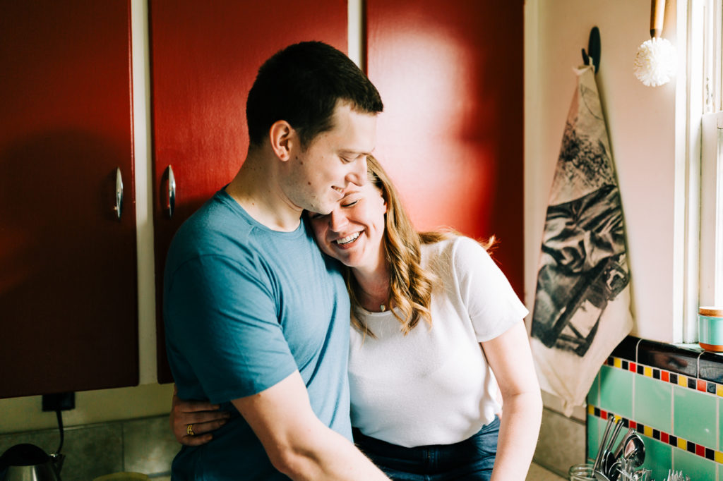 Choosing your wedding photographer.  Couple sitting together in the kitchen.